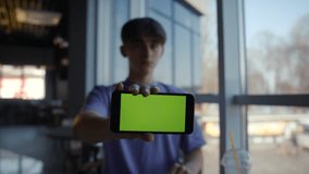 Front View Smart Phone Display for Game or Surfing or App. Green Screen Horizontal Mockup Keying for Tracking Presentation Advertising Video Content or News Blog. Man Closeup Holding Phone Chroma Key