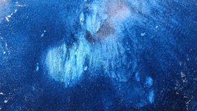 Slow motion, close up video design suitable for music or advertising. Shimmering movement of blue, silver paint.