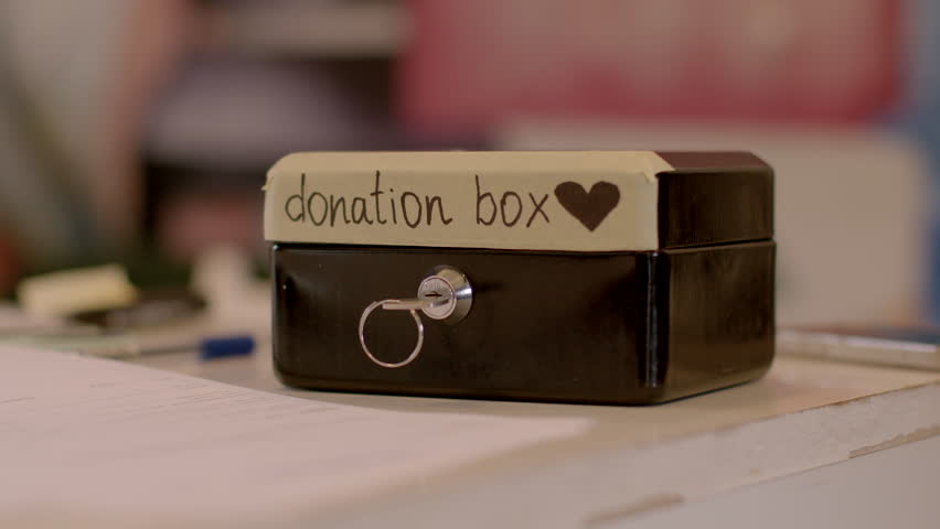 Donation box on the table. Volunteer fundraising is important for charities, a great way to get involved and support a cause that's close to your heart. Closeup indoors. Royalty-Free Stock Footage #1101726041