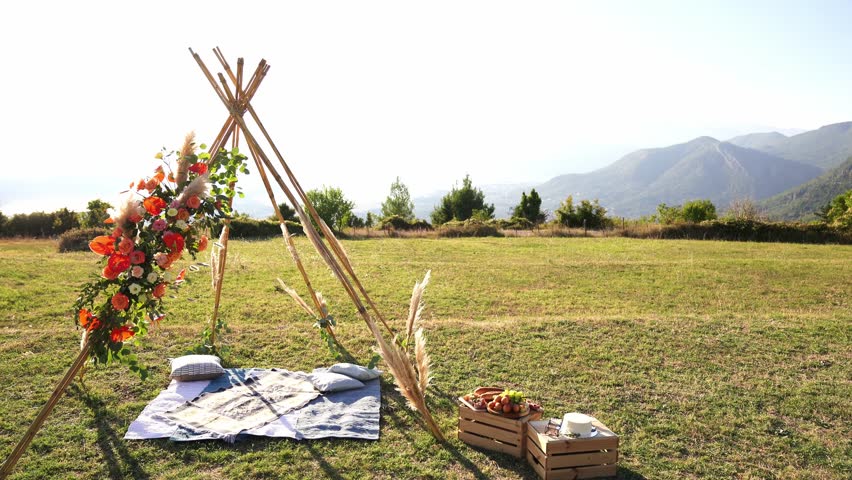 Wedding arch in the form of an Indian wigwam stands on a green meadow | Shutterstock HD Video #1101726761
