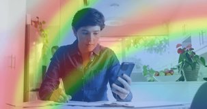 Animation of heart emojis and rainbow flag over caucasian woman using smartphone. Lgbtq, love, romance and celebration concept digitally generated video.