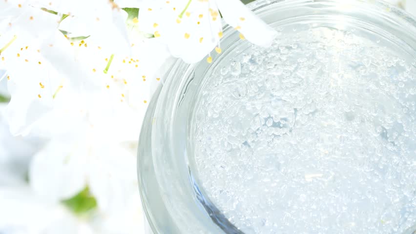 Closeup transparent cosmetic serum gel cream texture wirh cherry flowers blossom | Shutterstock HD Video #1101730899