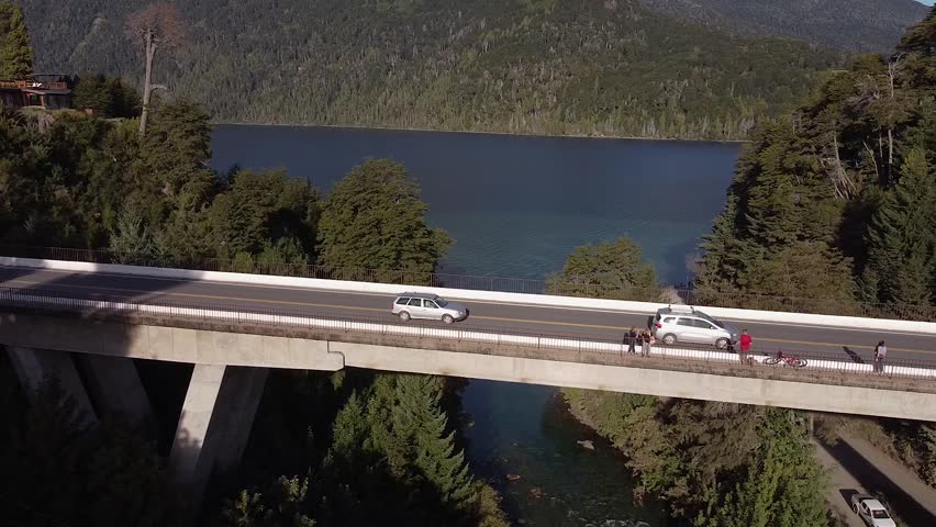 Bridge over Correntoso river with the Nahuel Huapi lake and the mountains in the background. Patagonia Argentina.