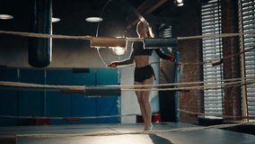 Professional young sportswoman boxer in sportswear with ponytail skipping rope on boxing ring in gym. She training alone. Girl jumping rope. Sport, workout, train, fighter training, jump rope concept. - Powered by Shutterstock - Get 15% off with code: PIKWIZARD15