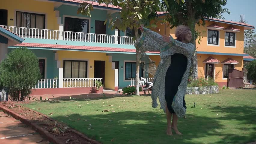 A young lady with purple short hair dances vigorously. Slow motion video