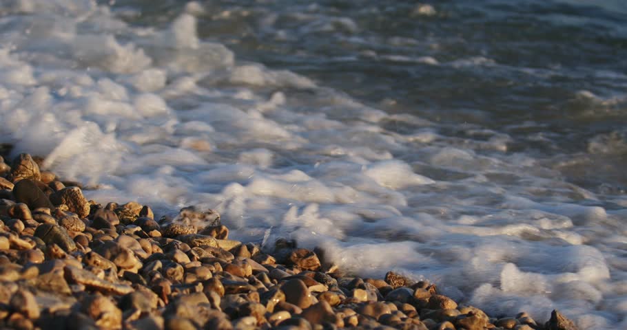 Waves on golden light of sunset on the pebble beach in Peljesac, the Adriatic Sea in Croatia | Shutterstock HD Video #1101739521