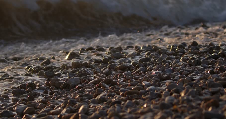 Waves on golden light of sunset on the pebble beach in Peljesac, the Adriatic Sea in Croatia | Shutterstock HD Video #1101739523