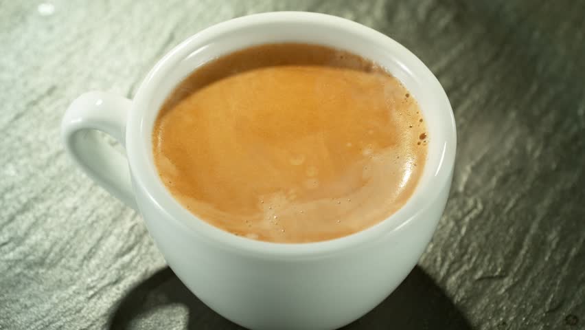 Super Slow Motion Detail Shot of Coffe Drop Falling into Fresh Espresso at 1000 fps. Camera move. Royalty-Free Stock Footage #1101739667