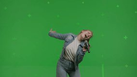 Close-up of attractive girl sings into a microphone and moves to the beat of music on Green screen. Young white woman having fun at karaoke - Powered by Shutterstock - Get 15% off with code: PIKWIZARD15