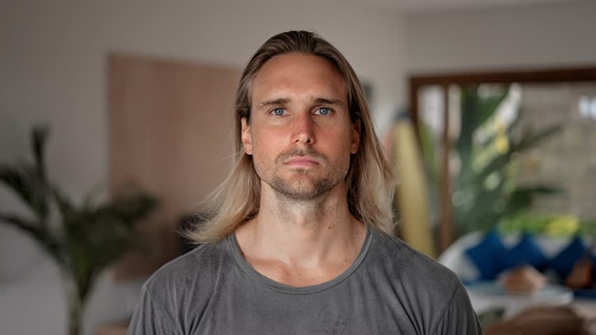 Happy male person face home portrait. Blue eyes look at camera close up. Joyful bristle surfer man long hair. Smiling shy guy. Kind people portraits. Young adult hippie inside house. Hipster hairstyle Royalty-Free Stock Footage #1101745339