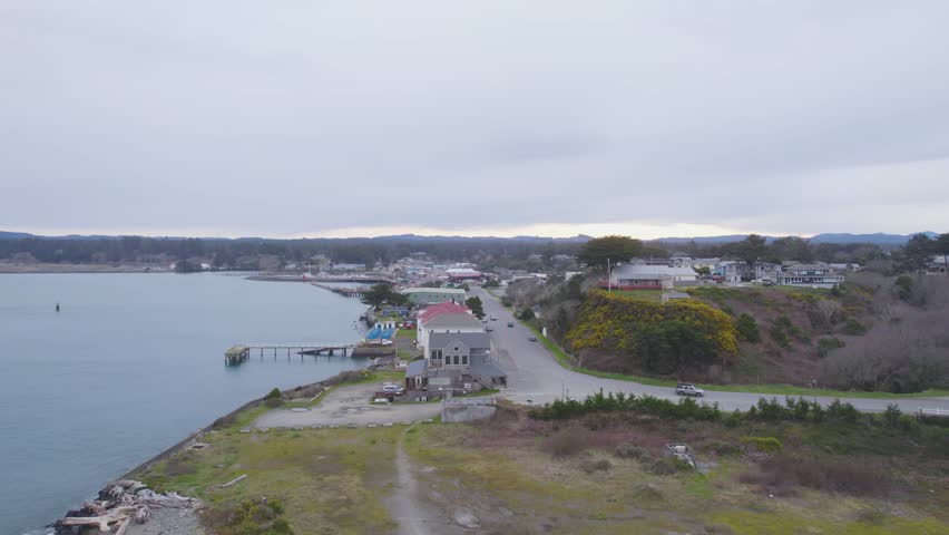 Aerial dolly over beachfront properties and homes on cloudy day in Bandon Oregon
