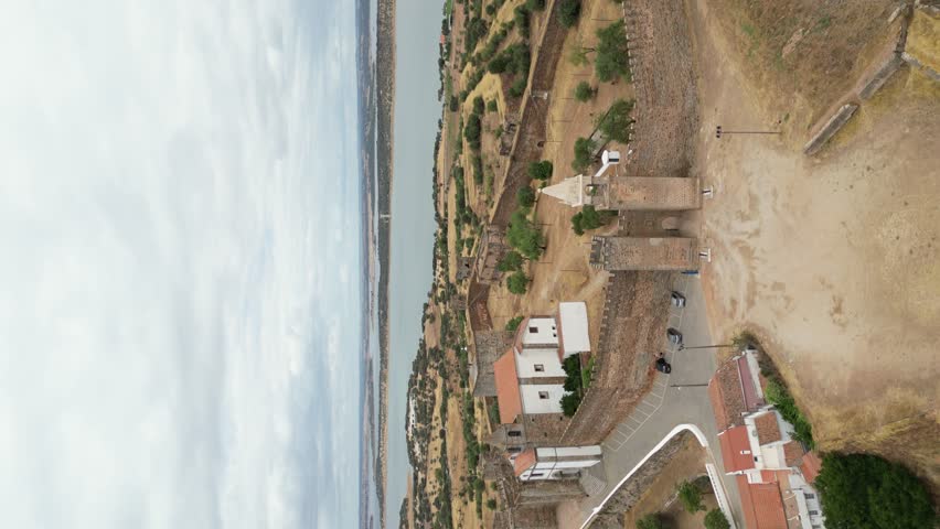 Vertical video of Mourao castle, scenic lake in Background, Aerial Orbiting shot 