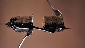 poured into two pieces of chocolate cake on forks on a brown background. vertical video - Powered by Shutterstock - Get 15% off with code: PIKWIZARD15