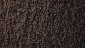 Aerial view of black agricultural land, fertile soil. Video by drone.