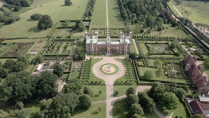 Aerial view orbiting Hatfield house majestic Tudor mansion, parkland and glorious landscaped gardens
