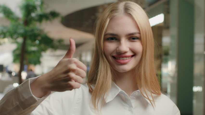 Portrait happy woman Caucasian businesswoman make thumb up hand gesture in modern shopping mall positive female entrepreneur girl showing like approve agree good result success recommend best choice Royalty-Free Stock Footage #1101760281