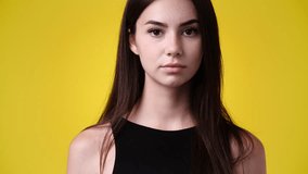 4k slow motion video of one girl posing for a video over yellow background.