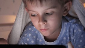 Closeup of child's face lying in bed with tablet computer. Children education, development, kids using gadgets secrecy, privacy. - Powered by Shutterstock - Get 15% off with code: PIKWIZARD15