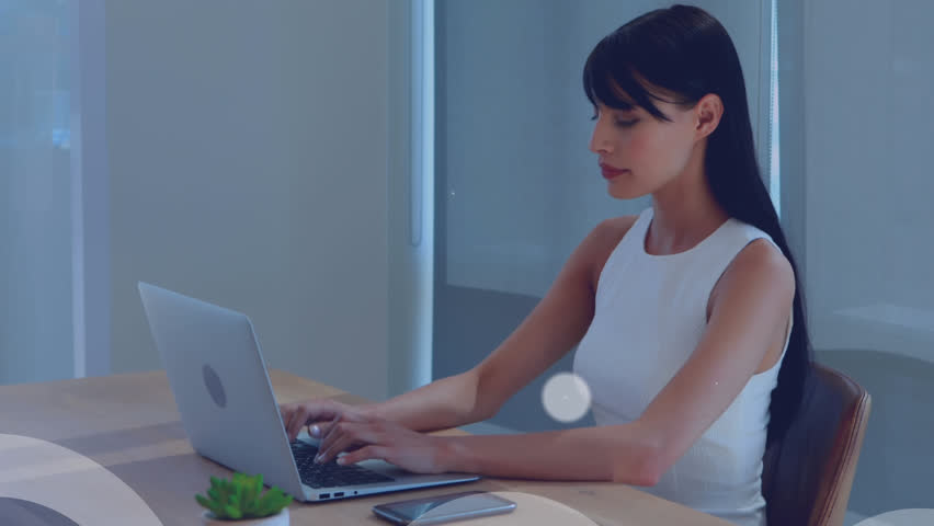 Network of digital icons against caucasian woman using laptop at office. global networking and business technology concept