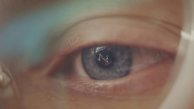 Close up view of bright blue eye with computer screen reflection, working late at night. Focused female with computer glasses checking the cryptocurrency price chart. - Powered by Shutterstock - Get 15% off with code: PIKWIZARD15