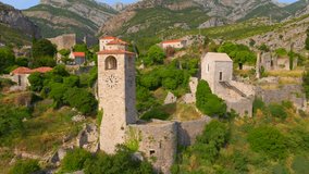 The drone footage captures the stunning ruins of Stari Bar, with stone buildings and a prominent clock tower standing tall amidst the remnants of history. The Old Bar in Montenegro is a fascinating