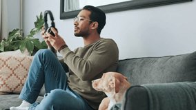 Man, phone and headphones on sofa with dog listening to music, podcast or online social media. Living room, relax and happy owner bonding with pet on couch, audio or radio streaming on mobile at home - Powered by Shutterstock - Get 15% off with code: PIKWIZARD15