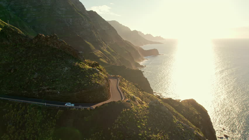 Coastline road at sunset on Gran Canaria Island, Canary Islands, Spain. Majestic volcanic mountains and Atlantic ocean landscape. Aerial view of Gran Canaria coast at sunset. Car trip in Spain Royalty-Free Stock Footage #1101785907