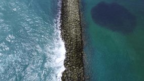 Aerial view of the flight from above over the sea stone dam breakwater. Calm beautiful video on the background for tourism, design and advertising.