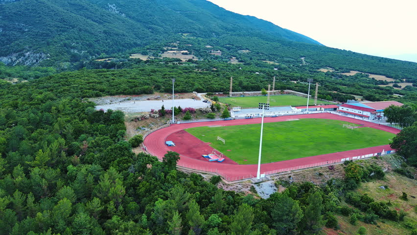 Large sports ground near the Greek town of Litochoro against the backdrop of the Mount Olympus and a cloudy sky