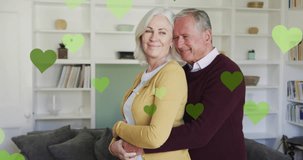 Animation of hearts over senior caucasian couple embracing. party and celebration concept digitally generated video.