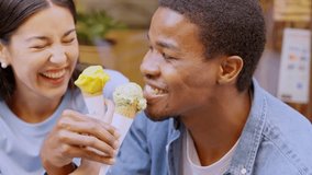 Woman and afro man having fun eating ice cream outdoors - Powered by Shutterstock - Get 15% off with code: PIKWIZARD15