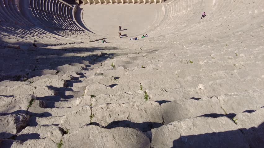 Amman, Jordan: The Roman theater  is a major landmark in Amman, Jordan capital city in the middle east on a sunny day with the citadel on the background. Shot with a tilt up motion.  