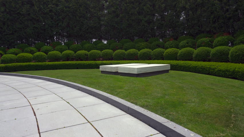 Herbert Hoover National Historic Site in West Branch, Iowa. The gravesite of President Hoover and Lou Henry Hoover. Two marble ledger stones mark graves in a semicircular landscaped plot with a flag.