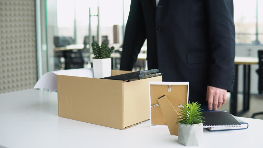 Senior employee putting his stuff from work desk in carton box, leaving job, close up. Old man is retiring. Retirement concept Royalty-Free Stock Footage #1101812145