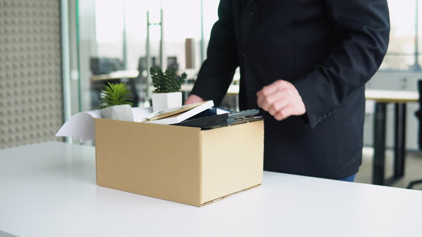 Senior employee putting his stuff from work desk in carton box, leaving job, close up. Old man is retiring. Retirement concept | Shutterstock HD Video #1101812145