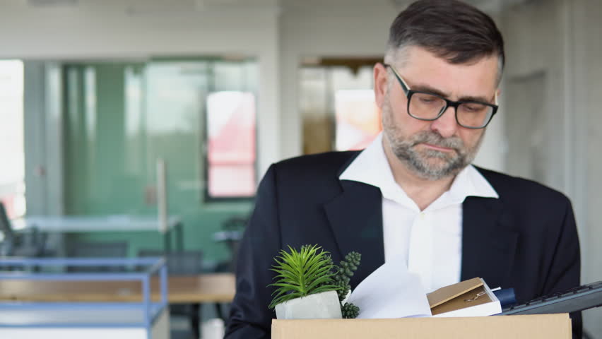 Unemployed senior man leaves of workplace. Dismissal from work. Job loss. Reduction of the company's staff. Retirement concept. Unemployment | Shutterstock HD Video #1101812157