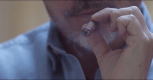 Man smoking cigar - slow motion close up video. Copy space.