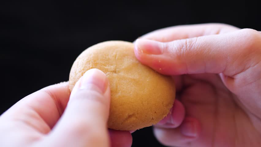 Female hands breaking a cookie with chocolate filling. Royalty-Free Stock Footage #1101818215