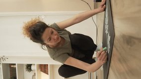 One woman female artist designer draw on the board on floor with chalk