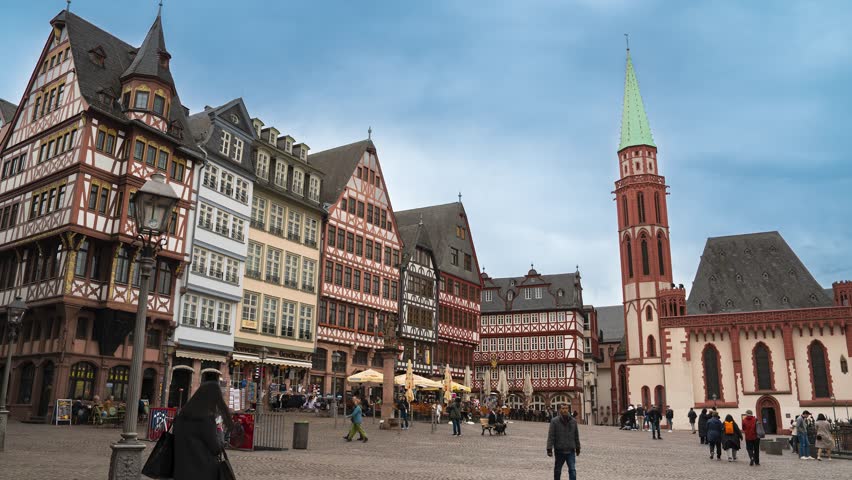 Frankfurt, Germany - Römerberg with Historical Market Place and German wooden Houses while Pedestrians pass by