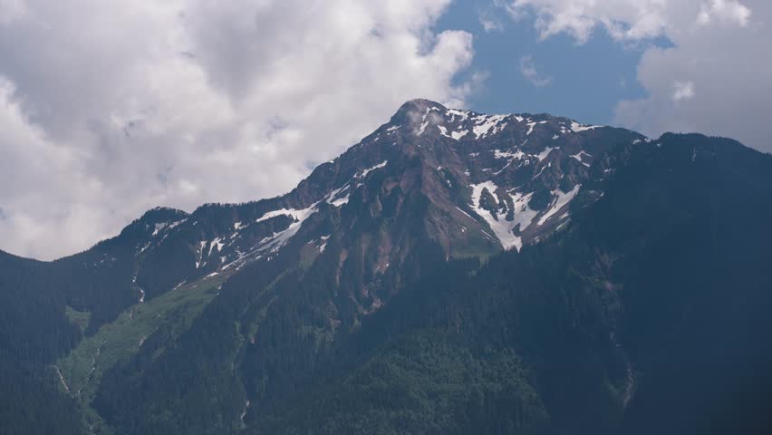 A time lapse of Mount Cheam in British Columbia Canada with clouds billowing overhead on a sunny day