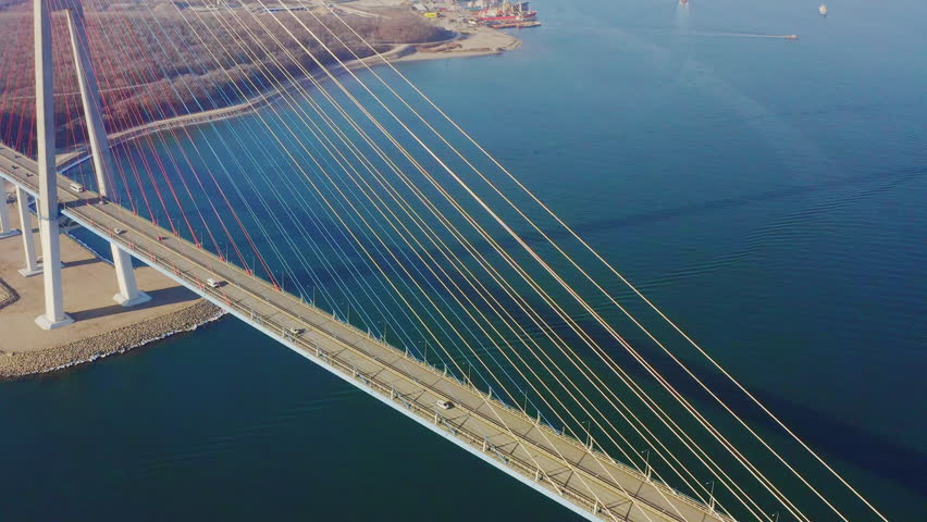Aerial view of the Russian bridge over the Eastern Bosphorus strait in Vladivostok. Cars driving on the roadway of the cable-stayed bridge Royalty-Free Stock Footage #1101831401