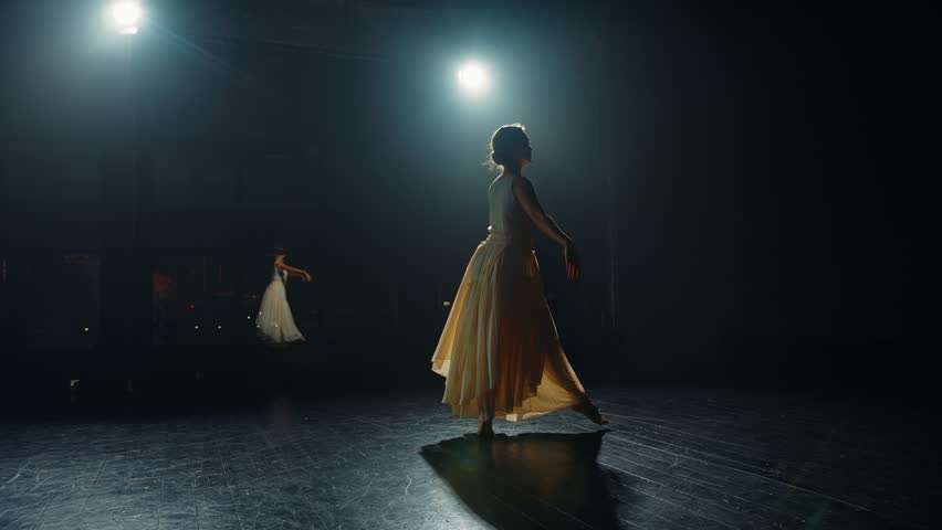 Young woman ballet dancer dances on stage in flowing dress. Choreographer setting ballet performance dancing on spotted stage Royalty-Free Stock Footage #1101832509