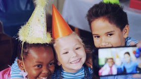 Animation of snow falling over diverse children with party hats at birthday party. party, childhood and celebration concept digitally generated video.