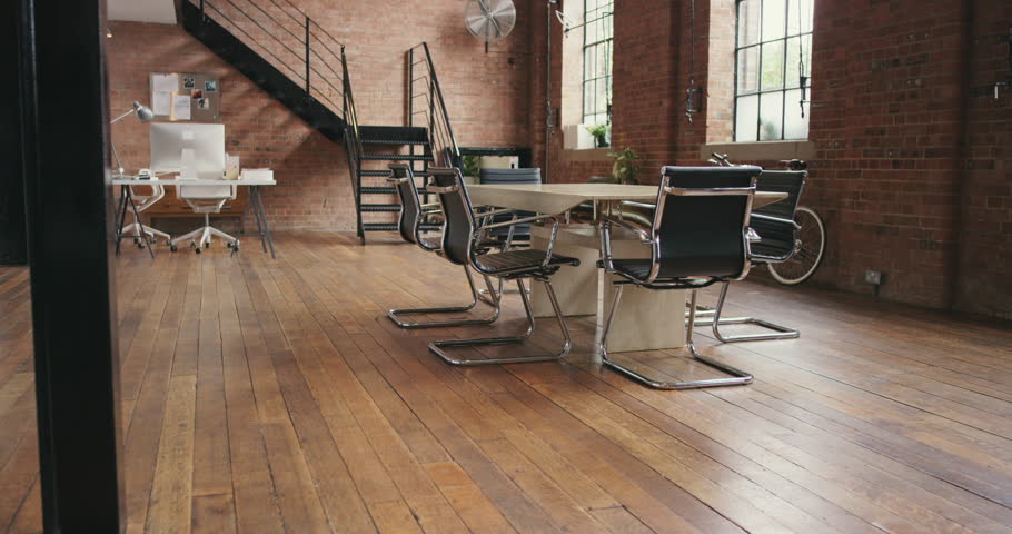 Office, room and creative space with table, desk and furniture for business meeting, collaboration and teamwork. Modern interior design in startup company, building and property for strategy planning