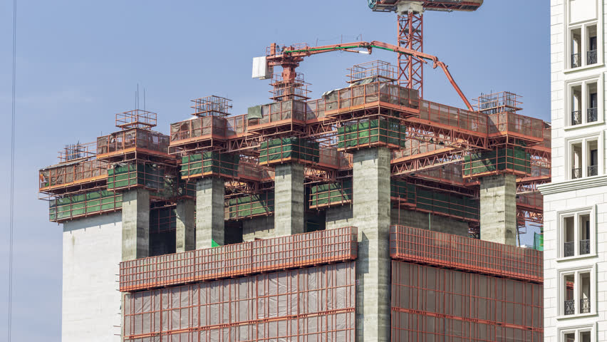 Footage 4k Timelapse, Overhead view of construction worker driving machine work control tower cranes on the top of the building, The skyscraper construction site at evening, Bangkok Thailand.