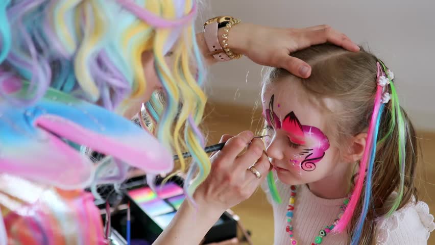 Artist painting little preschooler girl like unicorn on a birthday party Royalty-Free Stock Footage #1101842195