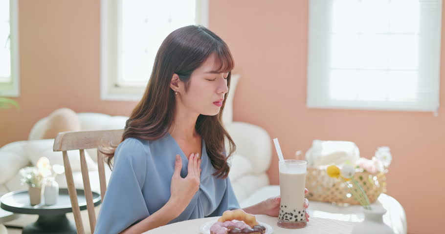 asian woman eat high sugar content food and has Gastroesophageal Reflux Disease feel regret