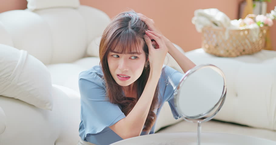 Asian girl worry hair loss - looking at the mirror seeing her losing hair wondering whats happening | Shutterstock HD Video #1101844601
