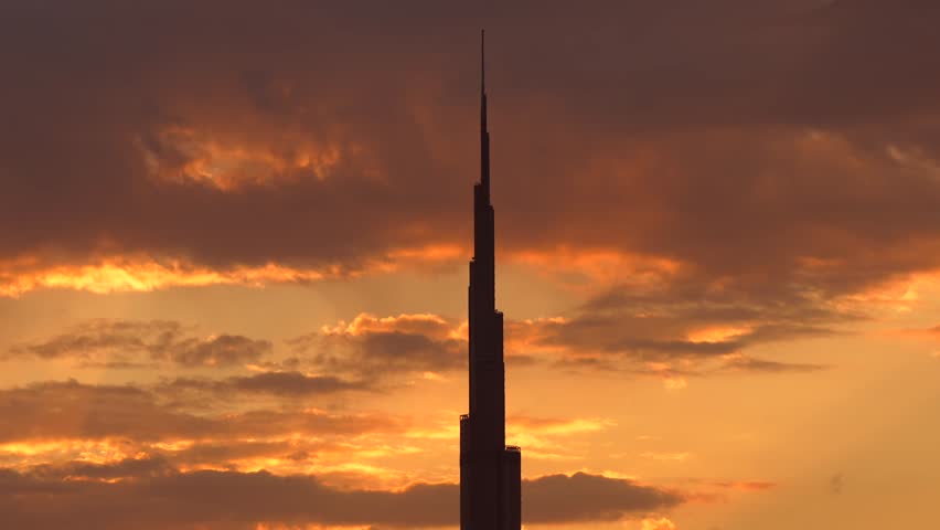 Silhouette of Burj Khalifa tallest building in the world against amazing orange sunrise sky in background. 4k travel video with Dubai landmarks.